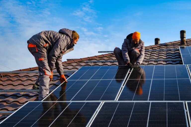 Workers installing roof solar panels